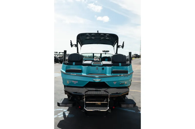 Slide: The Image of 2026 MasterCraft XT24 boat, rear view, vibrant blue, parked outdoors under a clear sky. - 8