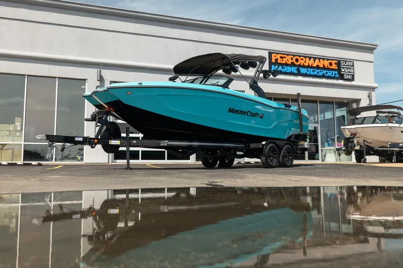 The Image of 2026 MasterCraft XT24 boat on trailer at Performance Marine Watersports dealership. - 1