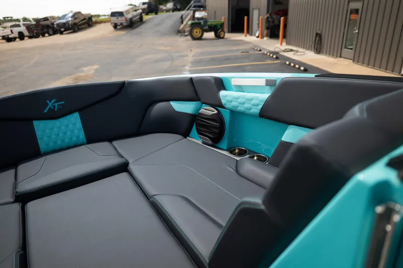 Slide: The Image of 2026 MasterCraft XT24 boat interior with sleek black and turquoise seating, cup holders, and speaker. - 41