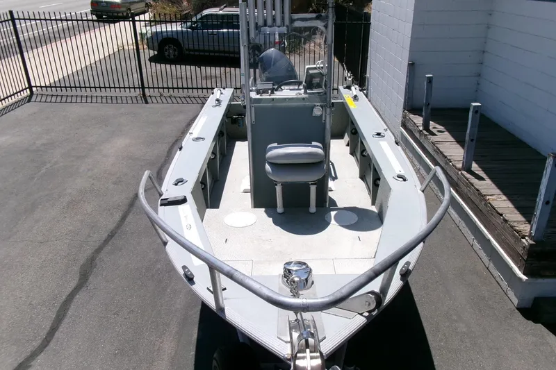 Slide: The Image of 2010 Klamath 19 Bayrunner Baja boat parked on pavement, featuring a central console and seating. - 21