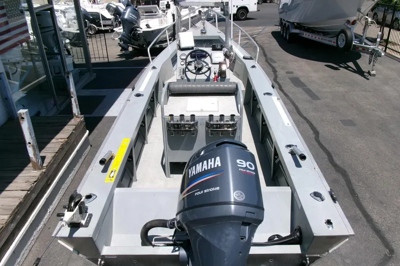 Slide: The Image of 2010 Klamath 19 Bayrunner Baja boat with Yamaha 90 outboard motor, docked outdoors. - 22