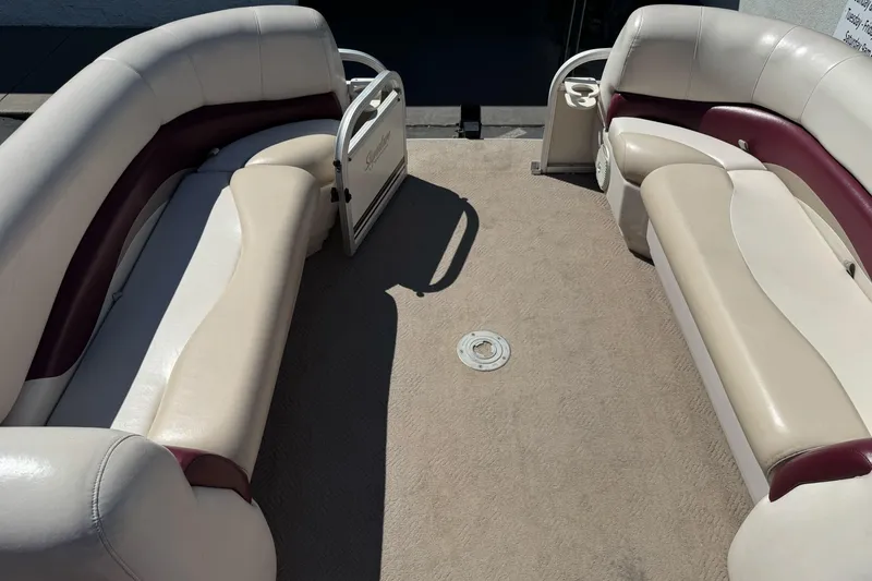 Slide: The Image of 2011 Sun Tracker Party Barge 21 interior with beige and maroon seating, spacious layout. - 13