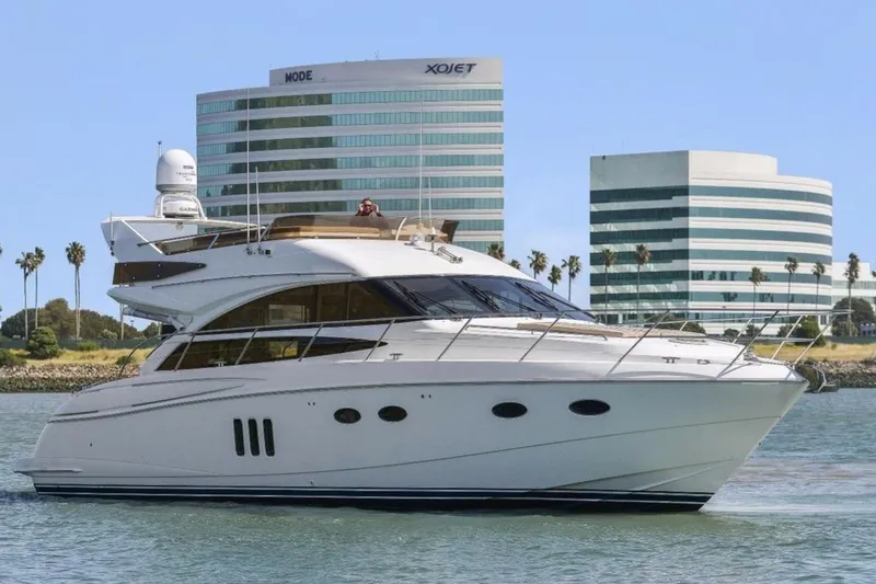 The Image of 2007 Viking Princess 54 Flybridge yacht cruising near modern office buildings. - 0