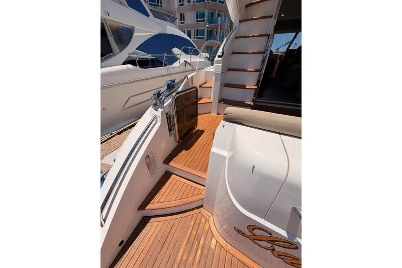 Slide: The Image of 2007 Viking Princess 54 Flybridge yacht with elegant wooden deck and staircase. - 12