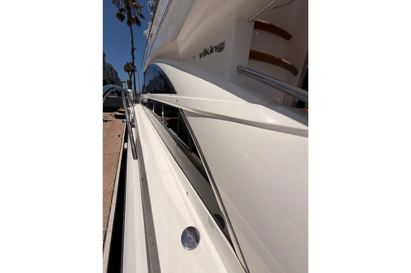 Slide: The Image of 2007 Viking Princess 54 Flybridge yacht, sleek white exterior, docked under clear blue sky. - 14