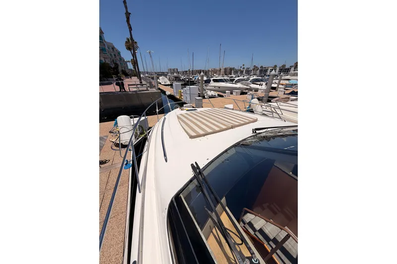 Slide: The Image of 2007 Viking Princess 54 Flybridge yacht docked at a marina under clear blue skies. - 16