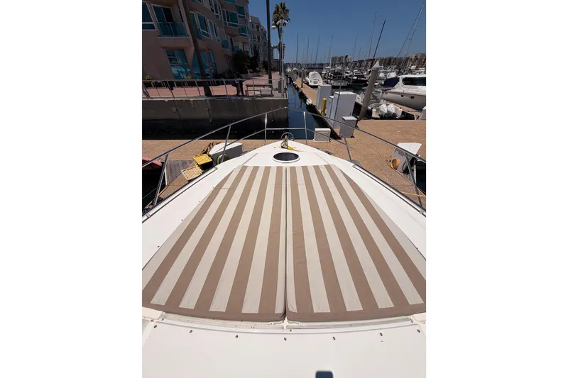 Slide: The Image of 2007 Viking Princess 54 Flybridge yacht with striped sunbathing deck in marina setting. - 17