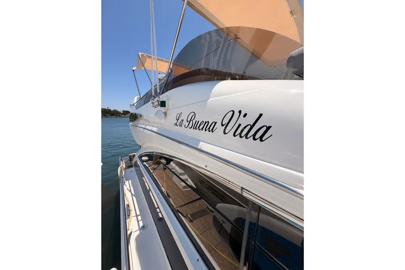 Slide: The Image of 2007 Viking Princess 54 Flybridge yacht named "La Buena Vida" docked on a sunny day. - 21
