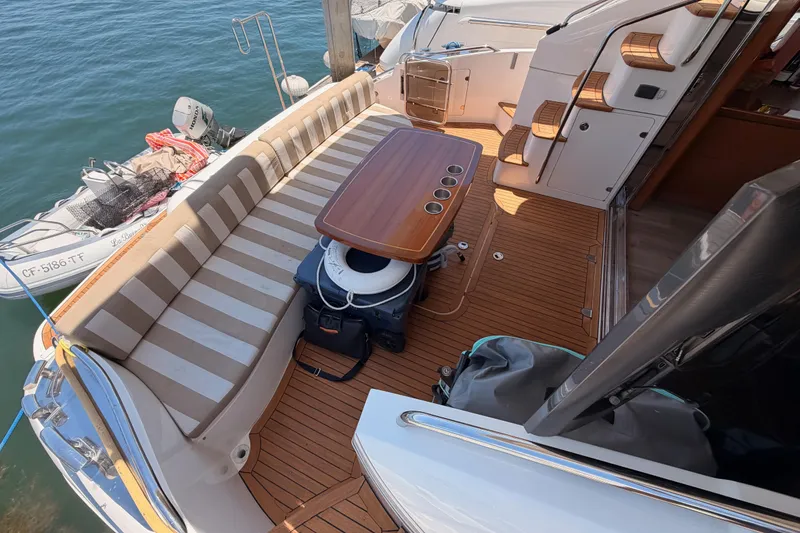 Slide: The Image of 2007 Viking Princess 54 Flybridge yacht deck with striped seating and wooden table. - 22