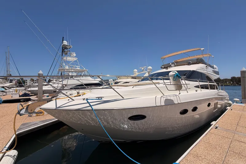 Slide: The Image of 2007 Viking Princess 54 Flybridge yacht docked at marina under clear blue sky. - 4