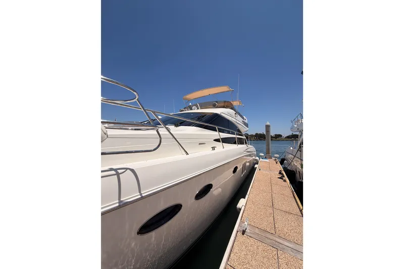 Slide: The Image of 2007 Viking Princess 54 Flybridge yacht docked under clear blue sky. - 5