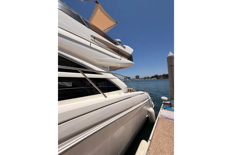 Slide: The Image of 2007 Viking Princess 54 Flybridge yacht docked by the water on a sunny day. - 7