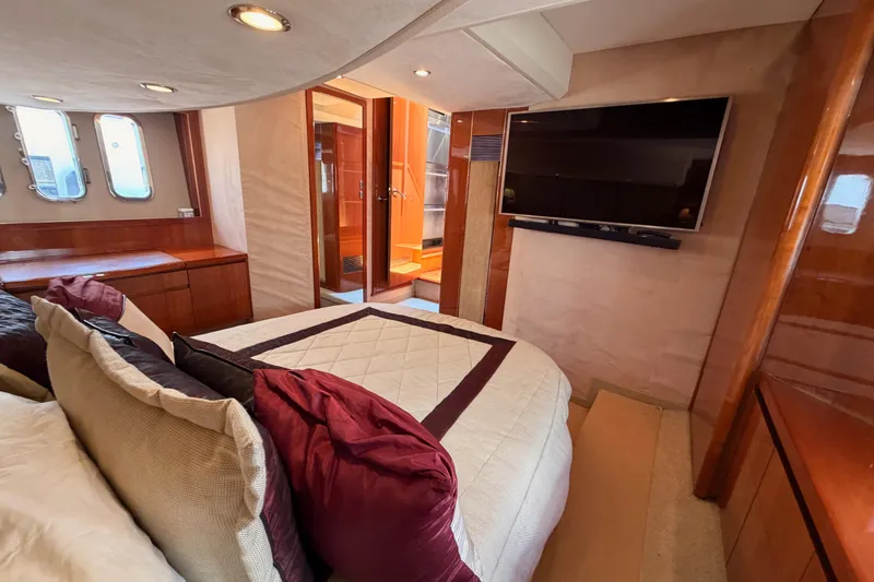 Slide: The Image of Luxurious 2007 Viking Princess 54 Flybridge yacht bedroom with TV and elegant wood finishes. - 70