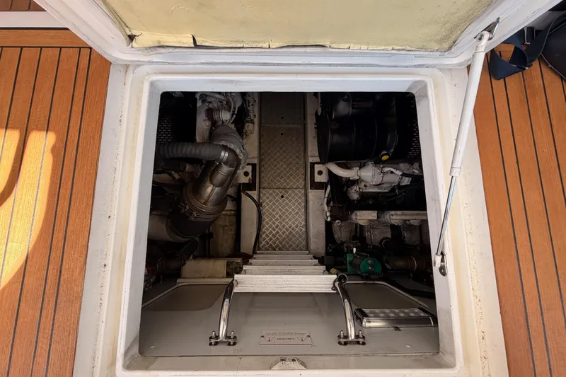 Slide: The Image of Engine compartment of 2007 Viking Princess 54 Flybridge yacht with visible machinery and ladder. - 93