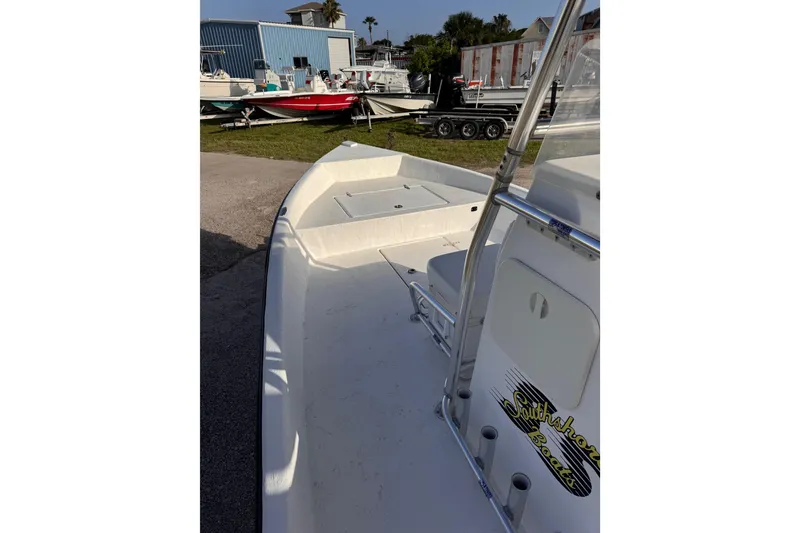 Slide: The Image of 2006 South Shore 26 boat, white deck, parked outdoors near other boats. - 18
