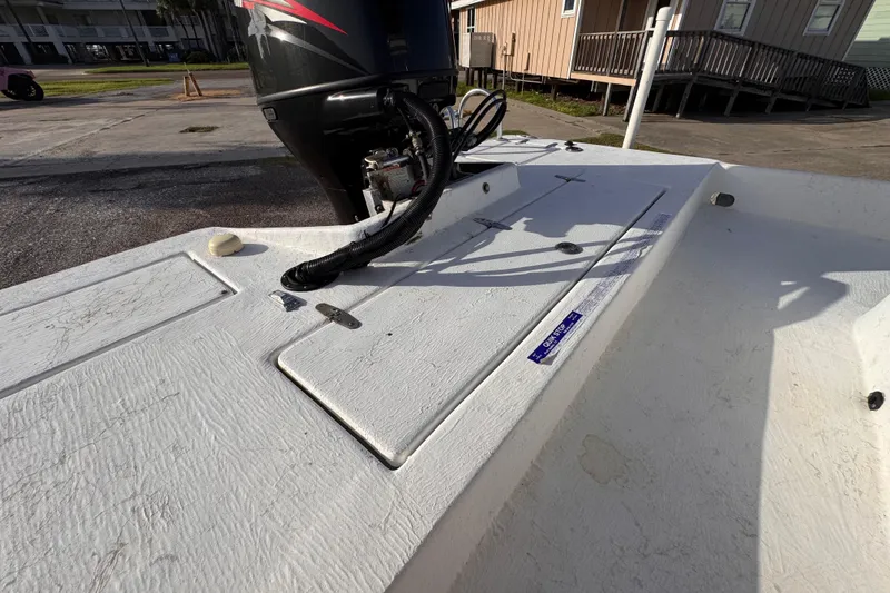 Slide: The Image of 2006 South Shore 26 boat deck with outboard motor in a sunny marina. - 26
