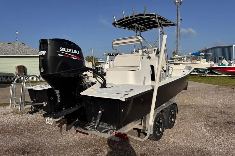 Slide: The Image of 2006 South Shore 26 boat with Suzuki 200 engine on trailer, parked outdoors. - 3