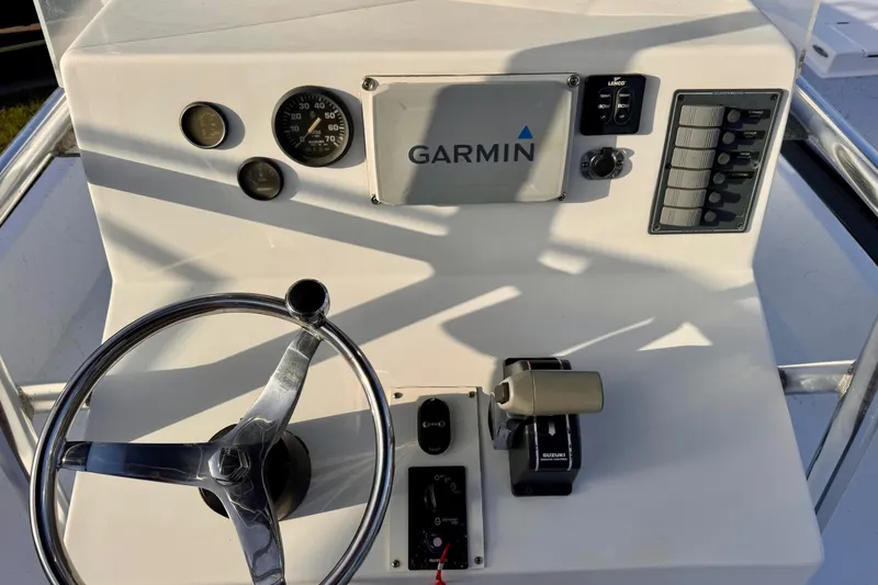 Slide: The Image of Boat dashboard with Garmin GPS, steering wheel, and controls, South Shore 26, 2006 model. - 8