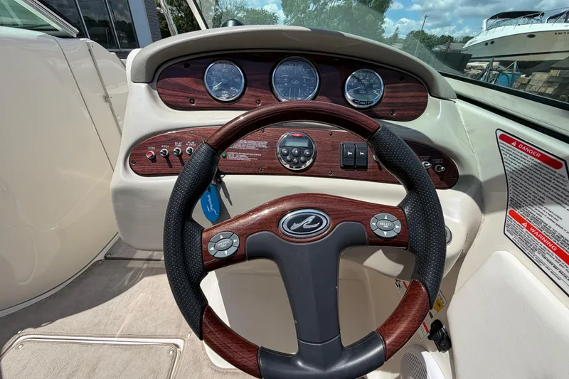 Slide: The Image of Steering wheel and dashboard of a 2004 Sea Ray 240 Sundeck boat. - 12