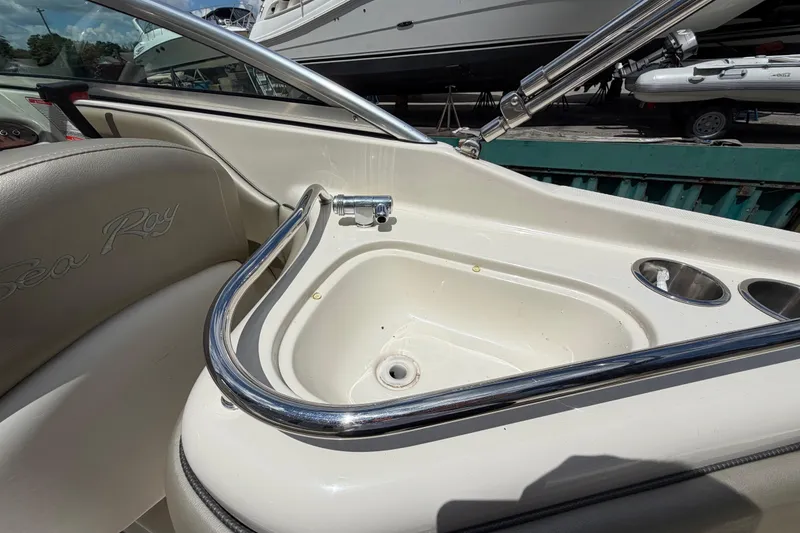 Slide: The Image of 2004 Sea Ray 240 Sundeck boat interior with sink and cup holders. - 17