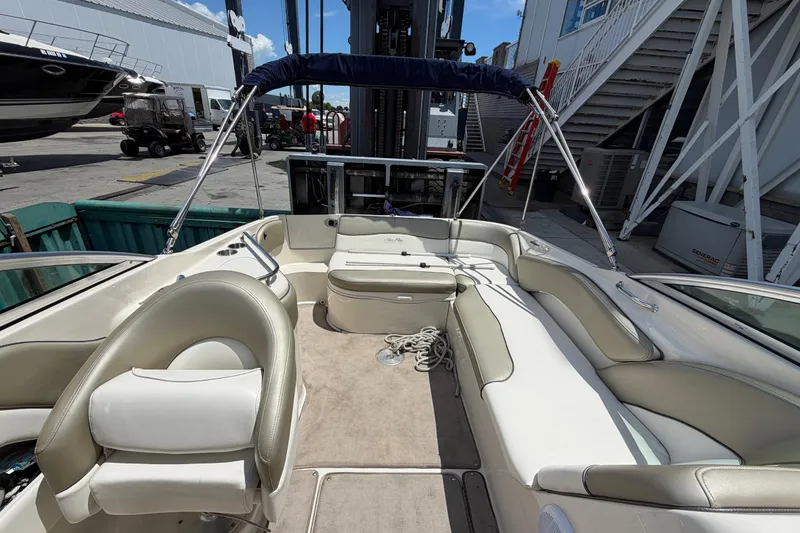 Slide: The Image of 2004 Sea Ray 240 Sundeck boat interior with seating and canopy in a marina setting. - 18