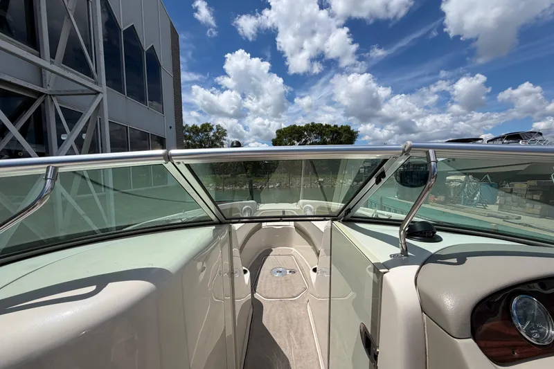 Slide: The Image of 2004 Sea Ray 240 Sundeck boat interior with clear skies and modern architecture. - 19