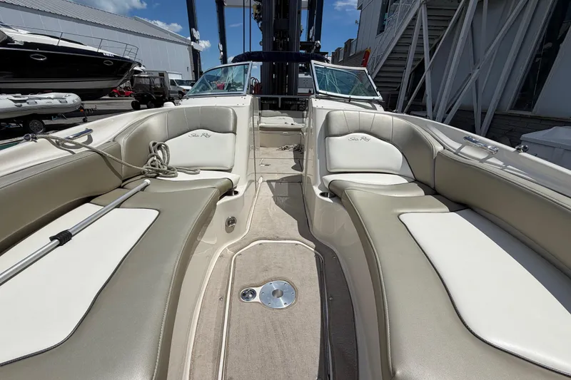 Slide: The Image of 2004 Sea Ray 240 Sundeck interior with beige seating and open deck layout. - 24