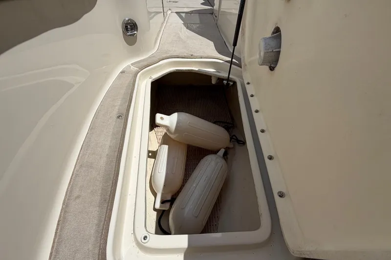 Slide: The Image of Storage compartment on a 2004 Sea Ray 240 Sundeck with boat fenders inside. - 28