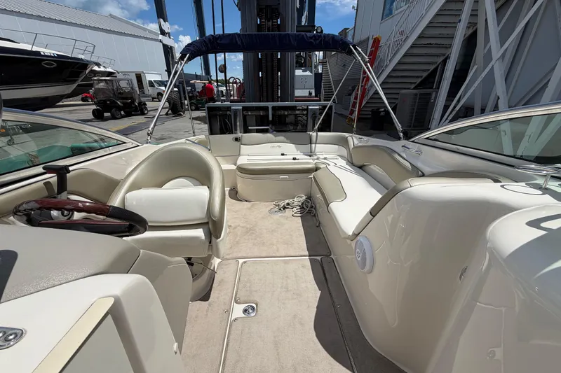 Slide: The Image of 2004 Sea Ray 240 Sundeck interior with seating, steering wheel, and open deck area. - 30