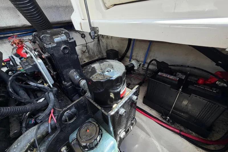 Slide: The Image of Engine compartment of a 2004 Sea Ray 240 Sundeck with visible battery and wiring. - 32