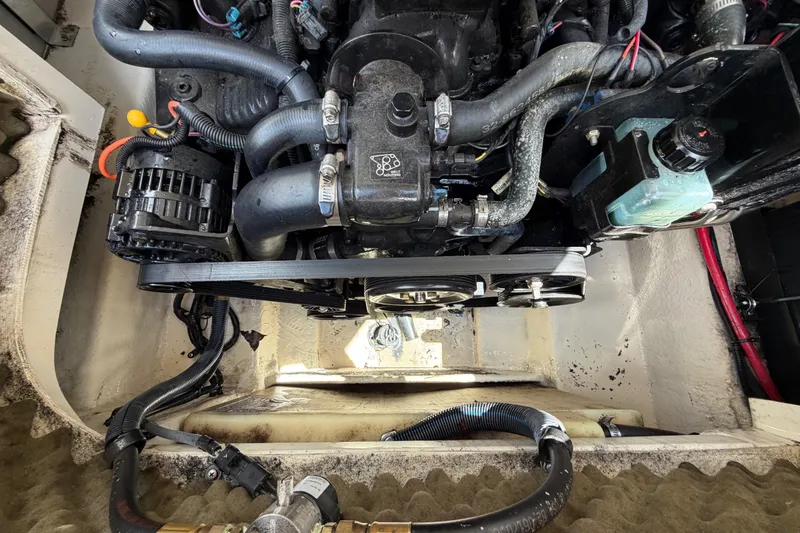 Slide: The Image of Engine compartment of a 2004 Sea Ray 240 Sundeck, showcasing hoses and components. - 35