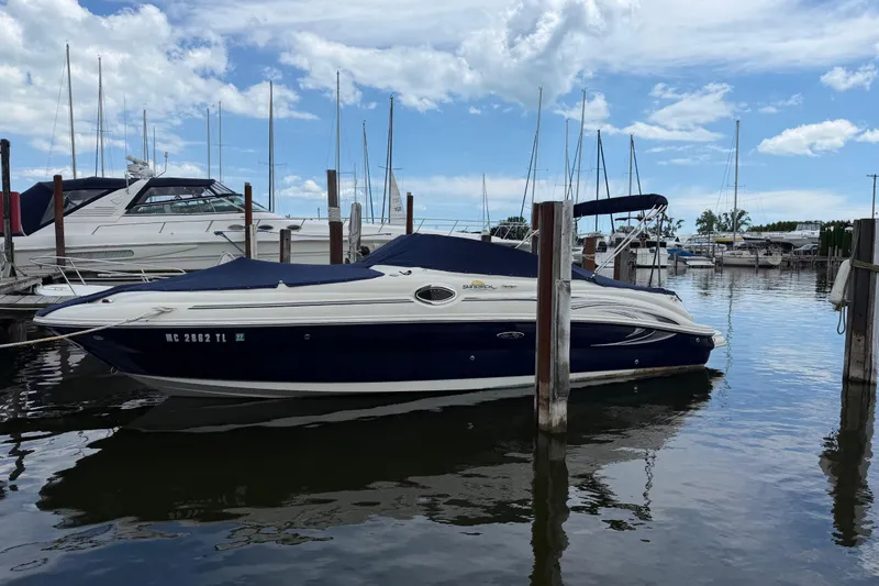 Slide: The Image of 2004 Sea Ray 240 Sundeck boat docked at a marina under a partly cloudy sky. - 37