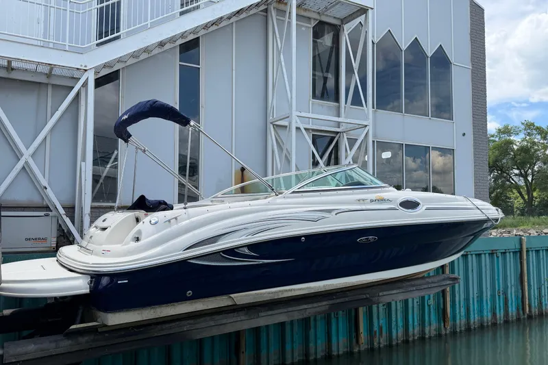 Slide: The Image of 2004 Sea Ray 240 Sundeck boat docked near modern building. - 5