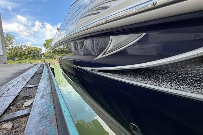 Slide: The Image of 2004 Sea Ray 240 Sundeck boat docked, showcasing sleek design and reflective water surface. - 7