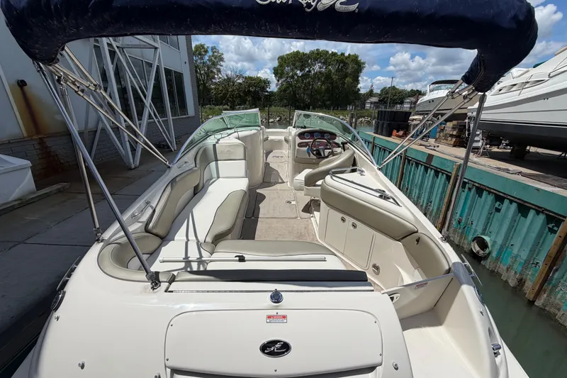 Slide: The Image of 2004 Sea Ray 240 Sundeck boat with spacious seating and canopy, docked under a sunny sky. - 8