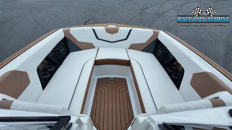 Slide: The Image of The image shows the bow area of a 2022 Nautique G25 with luxurious white upholstery. - 35
