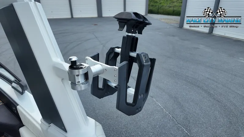 Slide: The Image of A wakeboard rack on a 2022 Nautique G25 boat, parked in front of a garage. - 43