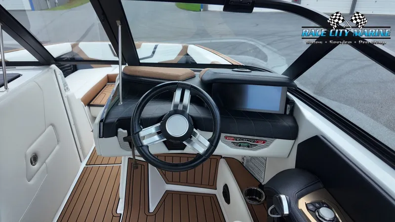 Slide: The Image of The image shows the cockpit of a 2022 Nautique G25 with a modern steering wheel and display. - 26