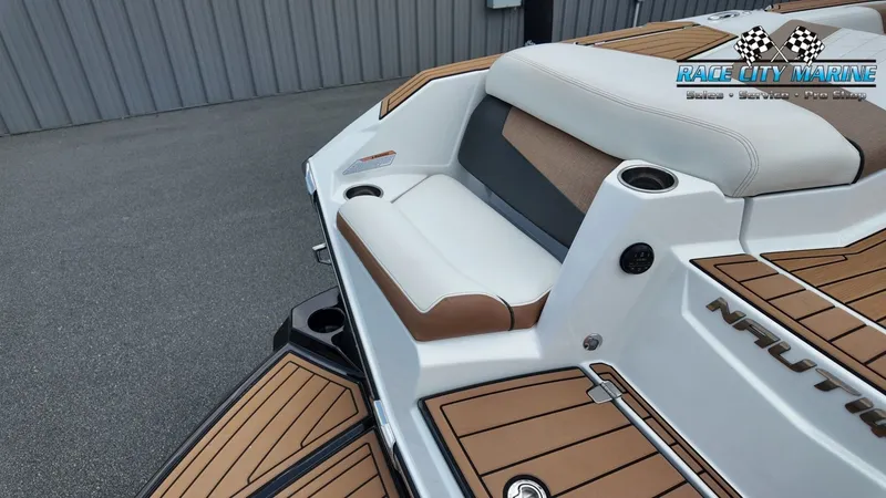 Slide: The Image of The image shows the stern of a 2022 Nautique G25 boat with sleek seating and teak-style flooring. - 12