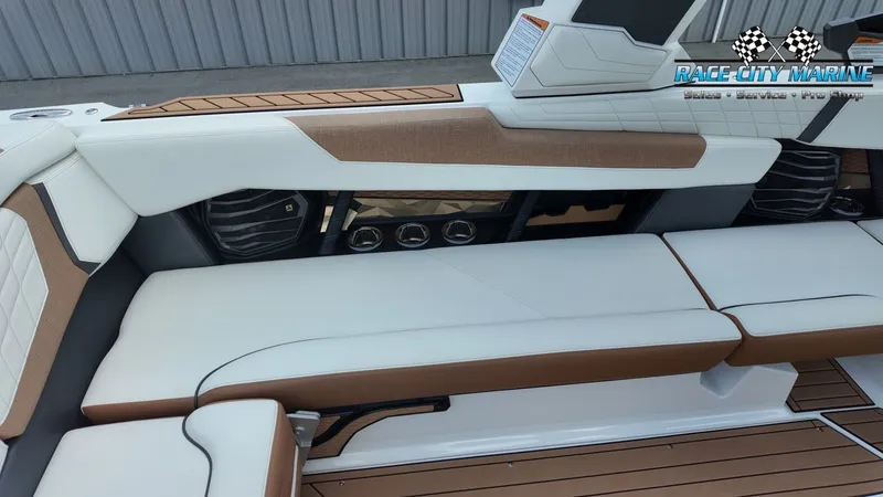 Slide: The Image of The image shows the luxurious interior of a 2022 Nautique G25 boat with white and brown seating. - 21