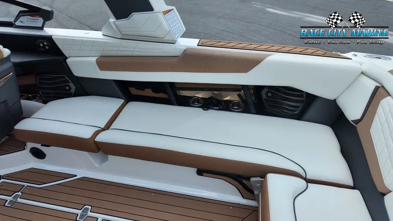 Slide: The Image of The image shows the luxurious interior of a 2022 Nautique G25 with white and brown seating. - 44