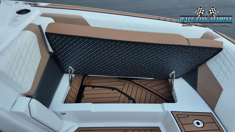 Slide: The Image of The image shows the seating area of a Nautique G25 boat with an open storage compartment. - 23