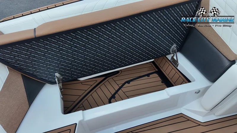 Slide: The Image of The image shows a storage compartment on a 2022 Nautique G25 boat with cushioned seating. - 17