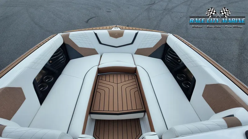 Slide: The Image of 2022 Nautique G25: Luxurious seating area with white and brown upholstery, perfect for relaxation. - 37