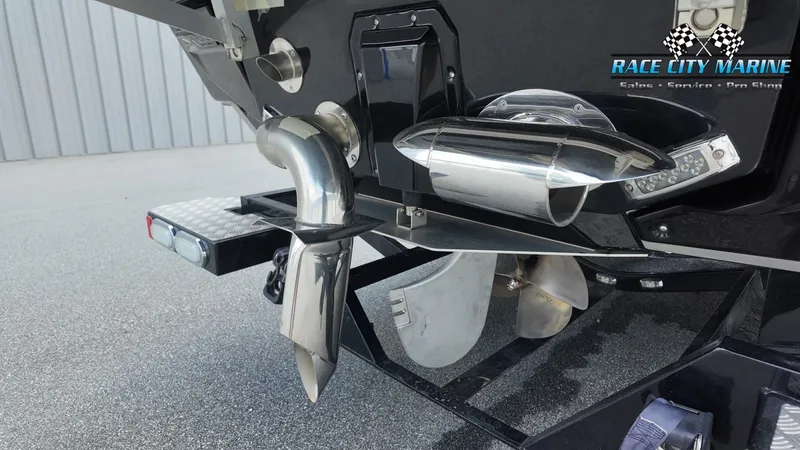 Slide: The Image of Close-up of a 2022 Nautique G25's stern with shiny exhaust and propeller. - 11