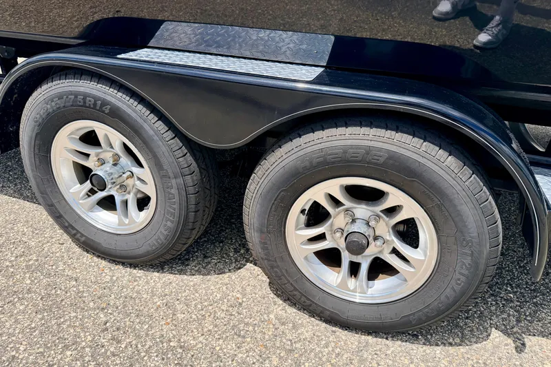 Slide: The Image of Trailer wheels of a 2015 Chaparral Sunesta 264 on asphalt surface. - 103
