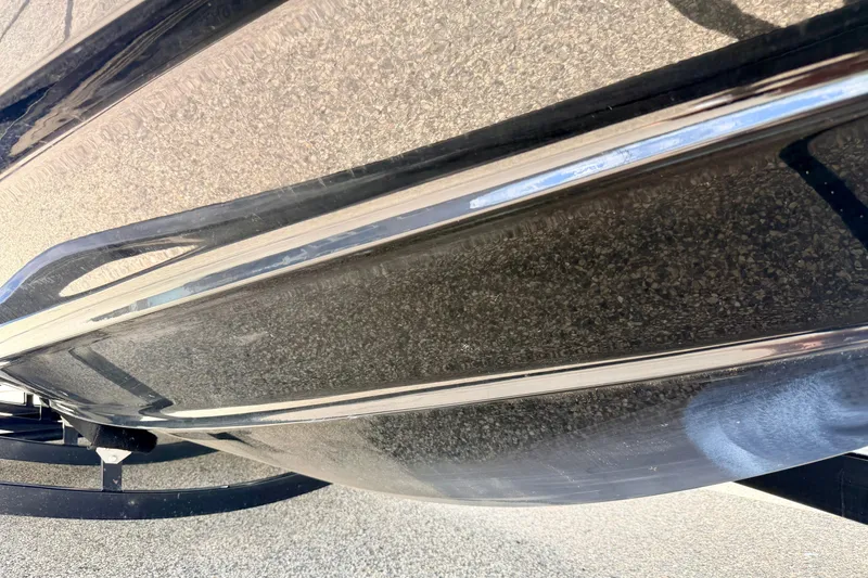 Slide: The Image of 2015 Chaparral Sunesta 264 boat hull, close-up view, showcasing sleek design and finish. - 105