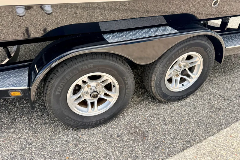Slide: The Image of Trailer wheels of a 2015 Chaparral Sunesta 264 boat on pavement. - 111