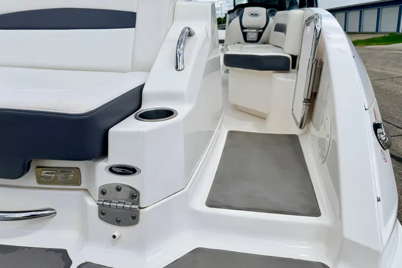 Slide: The Image of 2015 Chaparral Sunesta 264 boat interior, featuring seating and cup holder on a sleek deck. - 21