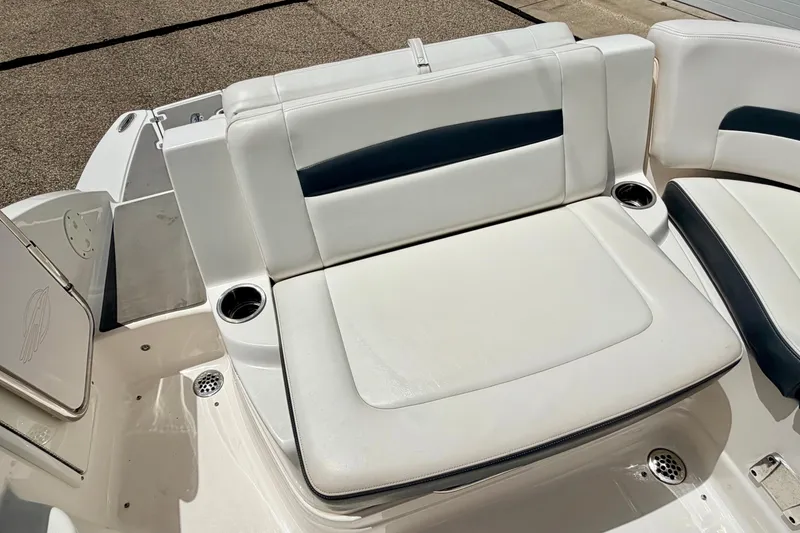 Slide: The Image of 2015 Chaparral Sunesta 264 boat seating area with white upholstery and cup holders. - 27